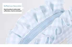 Detail of blue and white gingham cosmetic bag featuring ruffle edges and smooth zipper