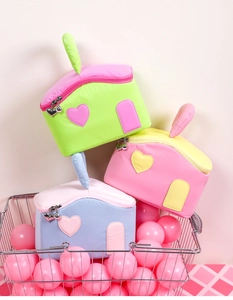Detail of house-shaped polyester makeup bags with heart charms in macaron colors