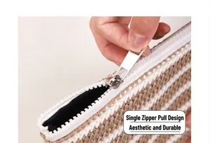 Detail of single metal zipper and textured stripe woven fabric on cosmetic bag
