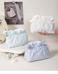 Dettaglio della trama jacquard floreale ricamata su borse per cosmetici con coulisse