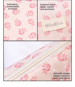 Detail showing pink floral lace fabric texture, brand label and zipper of makeup bag