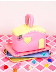 Detail of house-shaped makeup bag with heart patch and silver heart-shaped zipper pull