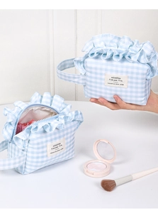Close-up of blue and white gingham makeup bag with ruffled edges and inner capacity