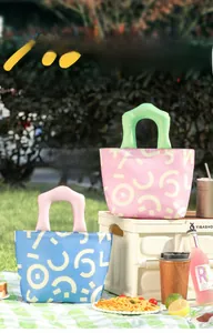 Close-up of geometric pattern lunch bags with thick contrast handles on grass