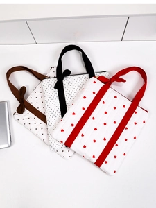 Detailed view of quilted cotton tote bags with heart and polka dot patterns and bows