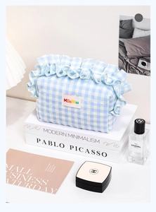 Neceser de cuadros azules con acolchado de corazón y ribete de encaje sobre libro