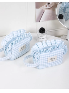 Detail of blue and white gingham cosmetic bags with ruffle trim and cotton handle