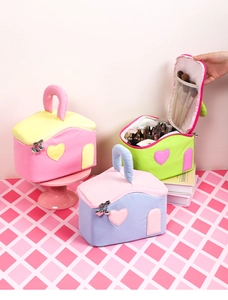 Detail of house-shaped makeup bags with heart zippers and interior brush pockets
