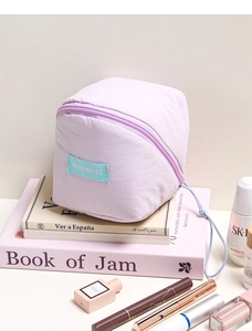 Macro detail of lavender cloud makeup bag with diagonal zipper and blue label branding