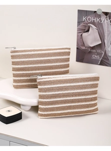 Macro shot of two woven striped cosmetic bags showing beige and brown texture details