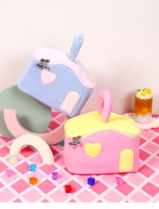 Detailed view of house-shaped polyester cosmetic bags in blue, pink, and yellow colors