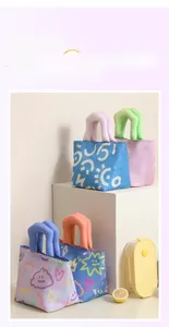 Close-up of colorful lunch bag featuring thick padded handles and cartoon doodle design