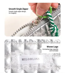 Dettaglio della pochette trapuntata argento con tiralampo verde e etichetta logo