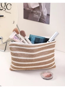 Detail view of woven makeup bag showing brown and white striped texture and interior space