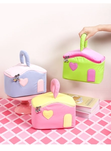 Detailed view of house-shaped quilted makeup bags with cherry zippers and soft handles