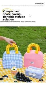 Detail of checkered and solid lunch bags with leather texture and yellow handles on grass
