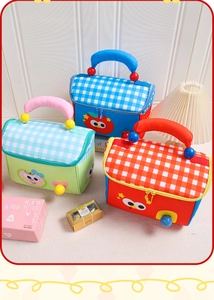 Detalle de bolsas térmicas en forma de manzana con tapas a cuadros y caras de dibujos