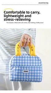Detail of blue plaid lunch bag with thick padded yellow handles and Dream label