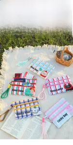Detailed close-up of colorful cartoon travel pouches with three-zipper storage on picnic mat