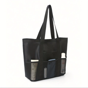 Close-up of black mesh tote bag with functional pockets for phone and toiletries