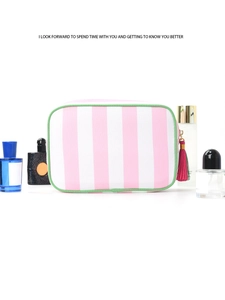 Detail of striped cosmetic bag with pink tassel zipper and green piping accents