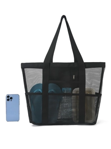 Detail view of large mesh beach bag showing side pockets with phone and water bottle