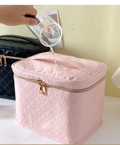 Waterdichtheidstest op roze gewatteerde make-up tas met gouden ritsen en handgreep