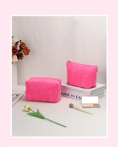 Dettaglio di borse per trucco in velluto rosa con cerniere metalliche su un tavolo