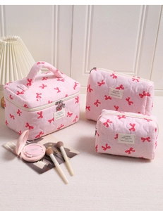 Set dettagliato di beauty case trapuntati a quadretti rosa con fiocchi rossi e manici