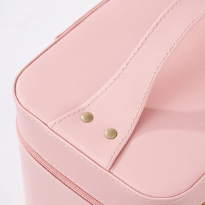 Roze make-uptas van leer met versterkt handvat en goudkleurige klinknageldetails