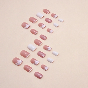 Faux ongles courts aurora blanc avec pétales de fleurs roses et fini perlé