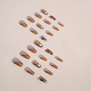 Cute ballerina press-on nails featuring orange bear designs and sparkling heart accents