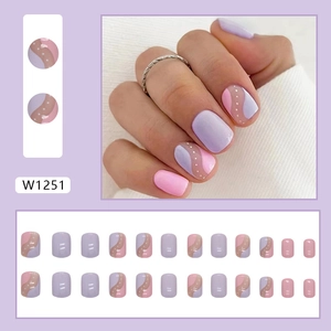 Short round press-on nails with pink and purple wavy patterns and white polka dots