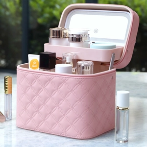 Pink quilted makeup case with integrated LED light mirror and spacious storage organizer