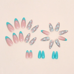 Almond press-on nails with blue French tips and delicate white flower vine designs
