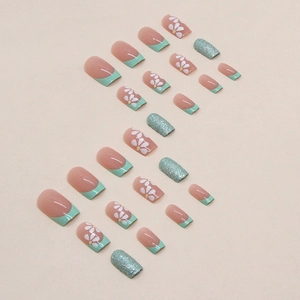 French tip press-on nails with daisy flower patterns and glitter in green and pink hues