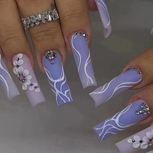 Detail of long ballerina press-on nails with purple gradient and floral crystal accents