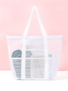 Detail of white mesh beach bag showing side pockets and large storage capacity