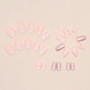 Oval peach pink press-on nails with marble texture, glitter sequins and rhinestones