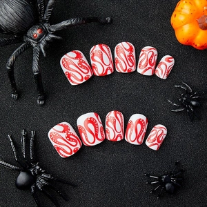 Short Halloween press-on nails with red snake patterns and blood vein textures on white base