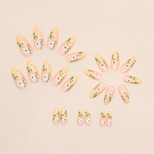 Floral gradient press-on nails with yellow and pink ombre base and white flower petals
