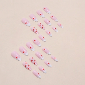 Almond-shaped white French tip press-on nails with gold lines and tiny red hearts