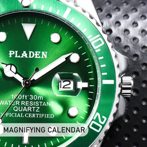 Macro detail of the green sunray dial and magnifying date window on a steel dive watch