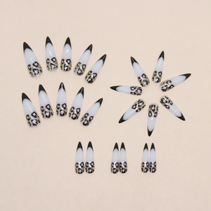 Long stiletto press-on nails with black French tips and pink gold glitter leopard print