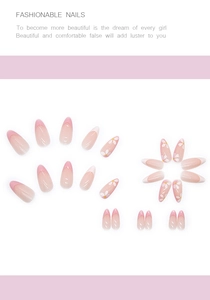 Détail de faux ongles en amande avec dégradé rose et motifs de fleurs blanches peintes
