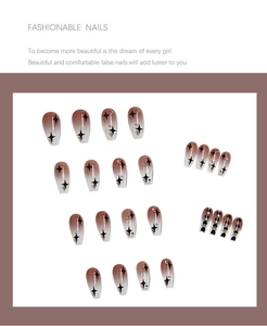 Detail of gradient brown press-on nails featuring black star patterns and rhinestones