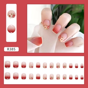 Short round press-on nails set with deep red gradient and delicate floral pattern