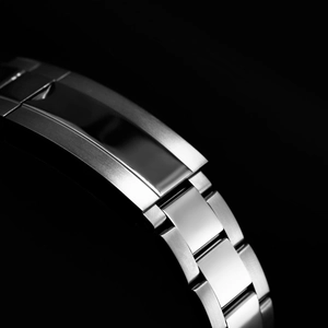 Close-up of brushed stainless steel watch strap with oyster links on a black background