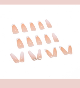 Flat lay of 24pcs long coffin press-on nails with nude French tips and rhinestone accents