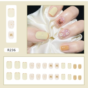 Detail view of 24pcs press-on nails with cartoon bear and daisy patterns in cream tones